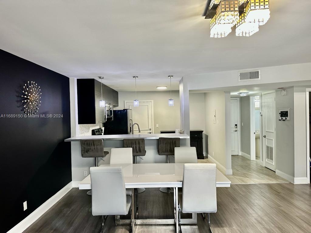 a view of a dining room with furniture a chandelier and wooden floor