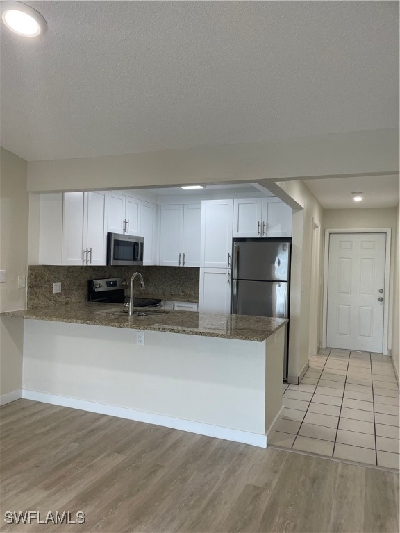 a kitchen with stainless steel appliances a refrigerator sink and microwave