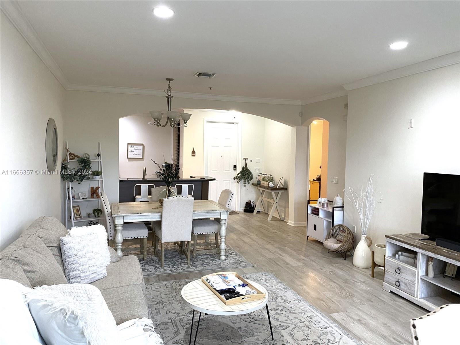 a living room with furniture a flat screen tv and a large window