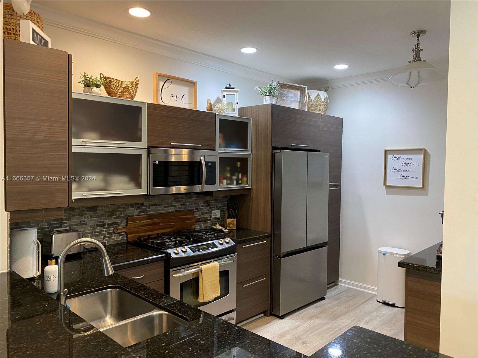 a kitchen with stainless steel appliances granite countertop a refrigerator and a stove top oven