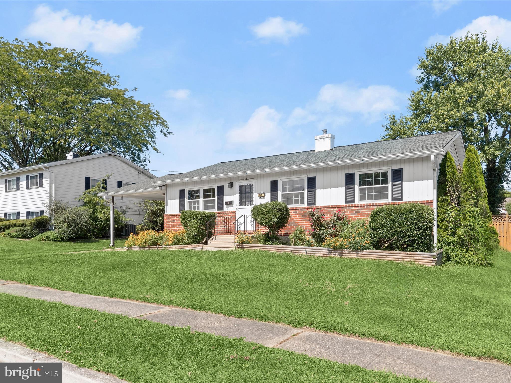 a front view of house with a yard and green space