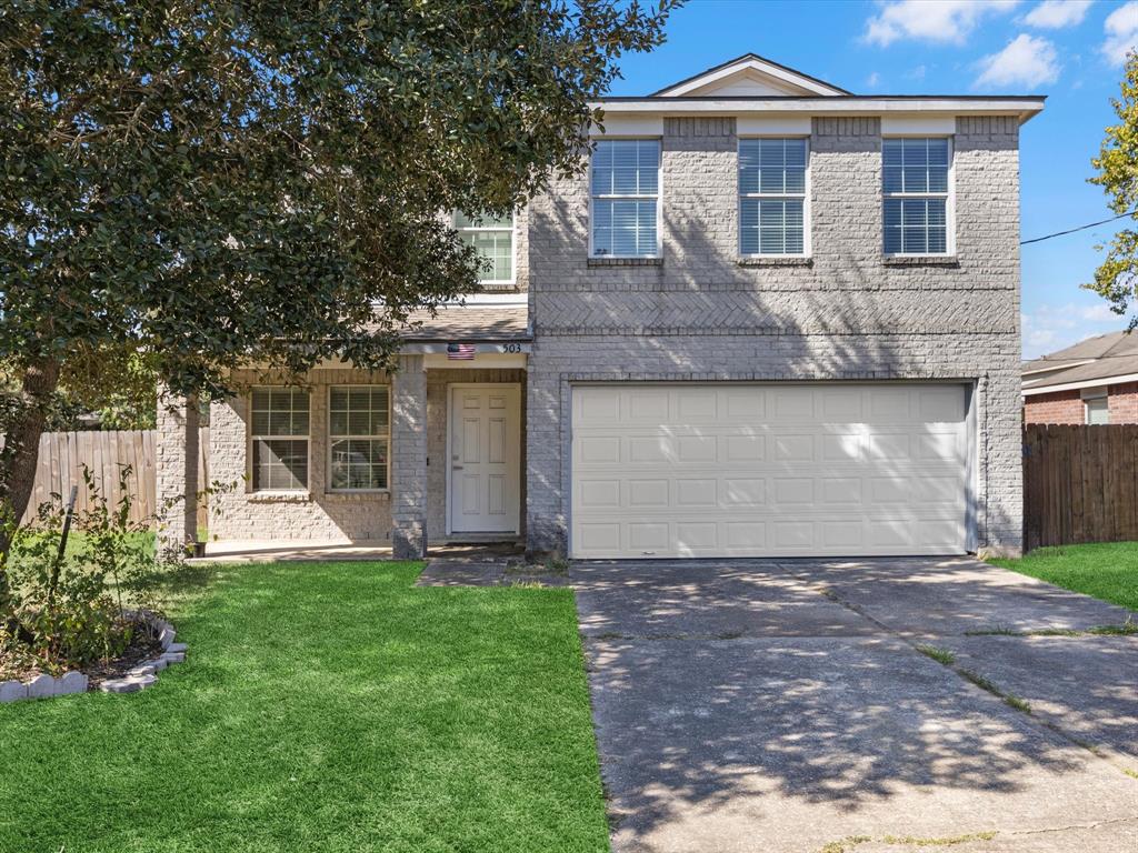 a front view of a house with a yard and garage