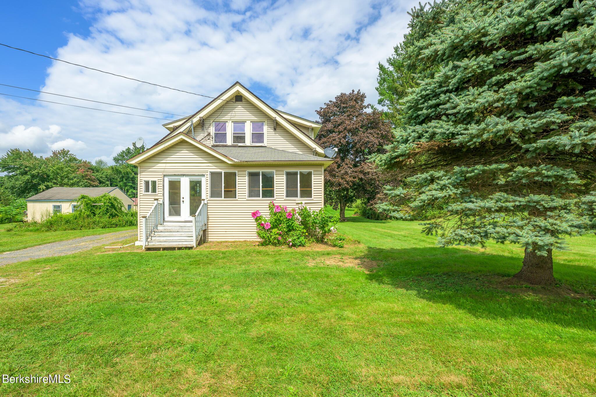 a front view of a house with a garden