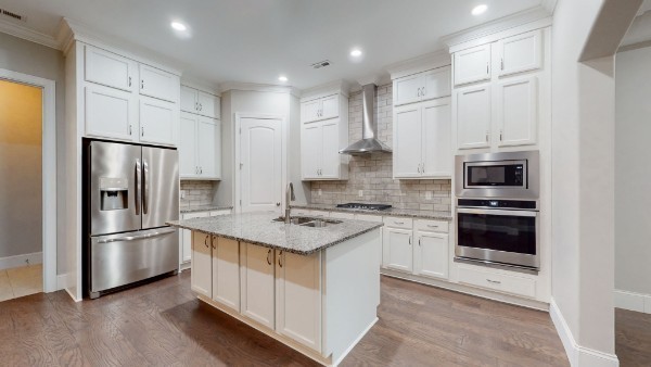 a kitchen with stainless steel appliances granite countertop a refrigerator stove and microwave