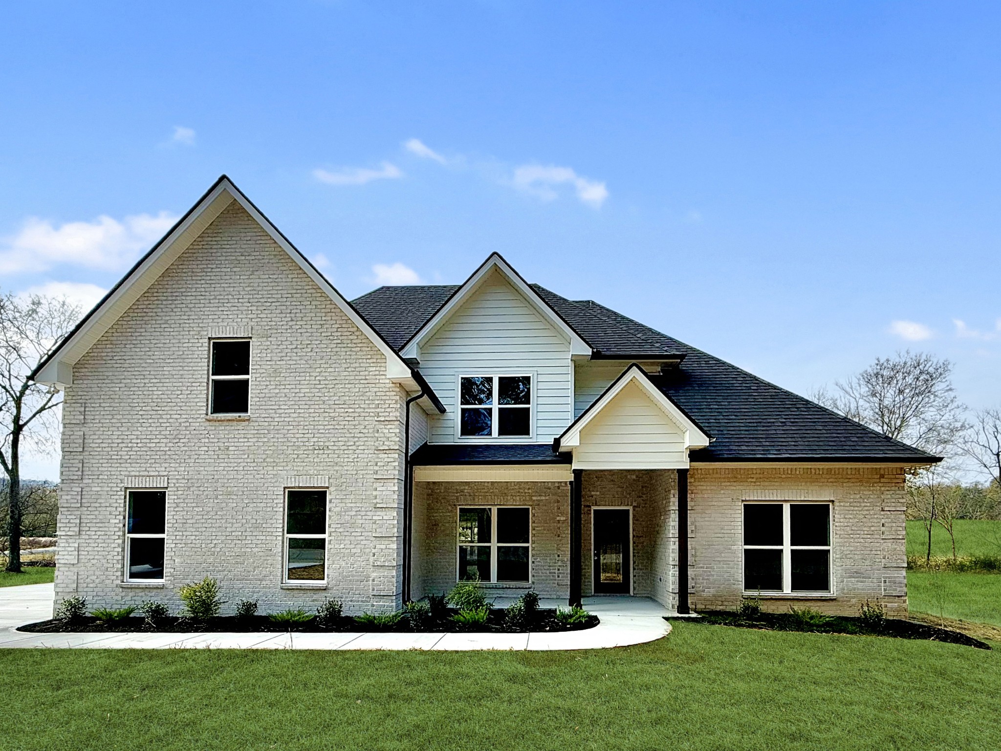 a front view of a house with a yard and green space