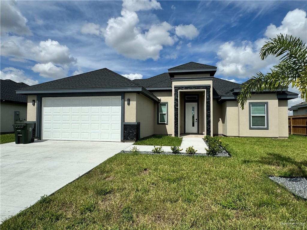 Prairie-style home with a front yard and a garage