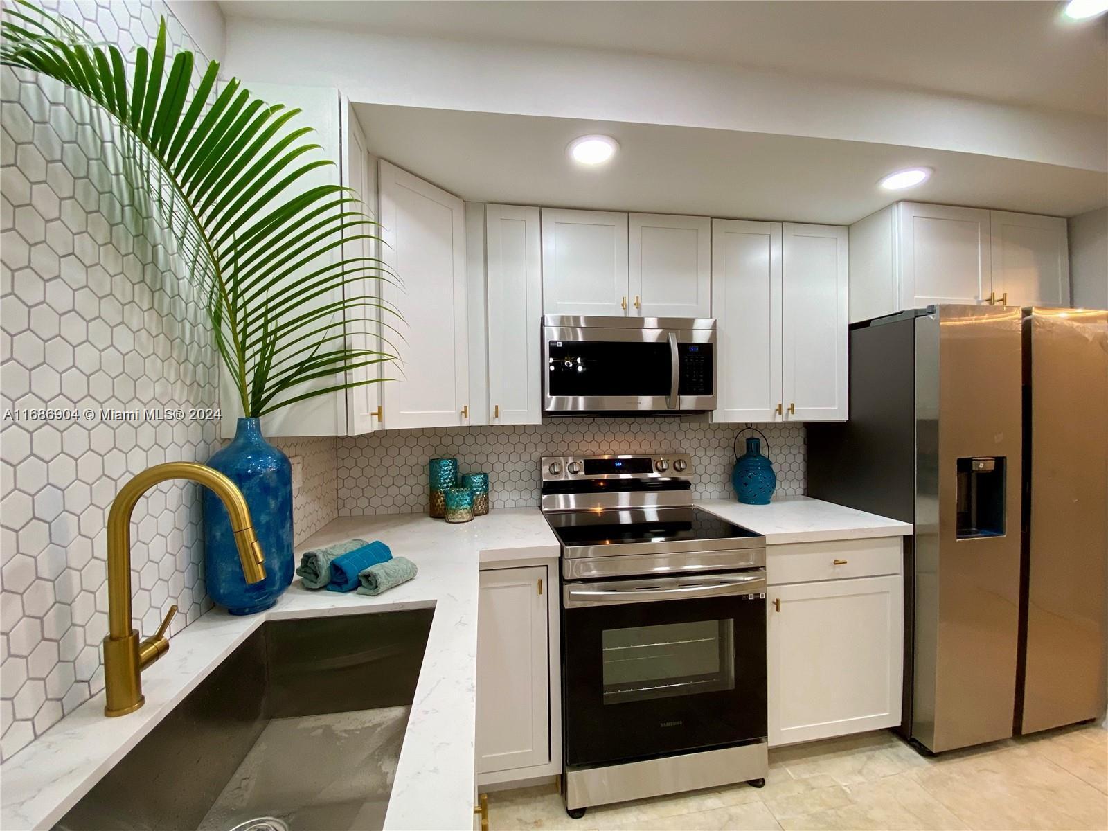 a kitchen with stainless steel appliances a stove microwave sink and refrigerator