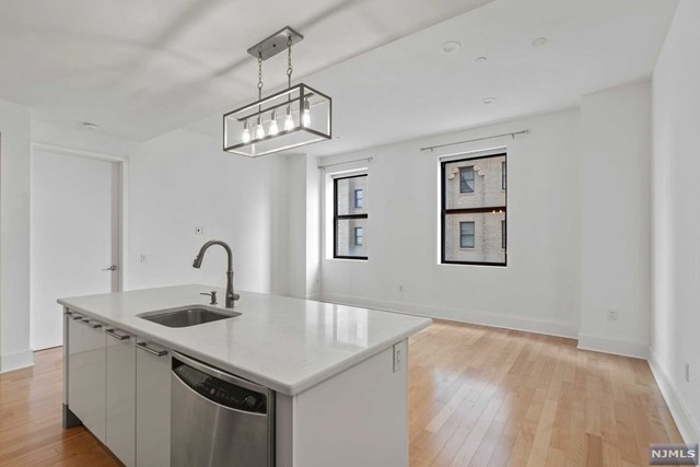 a kitchen with a sink cabinets and wooden floor