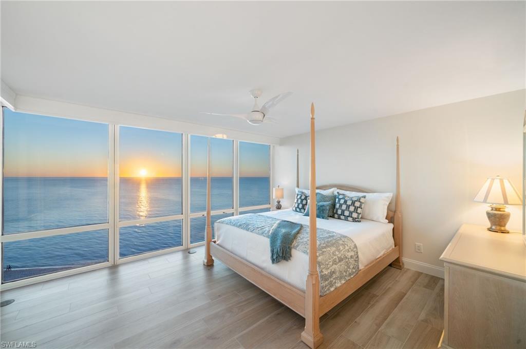 Bedroom featuring access to outside, ceiling fan, a water view, and light hardwood / wood-style floors