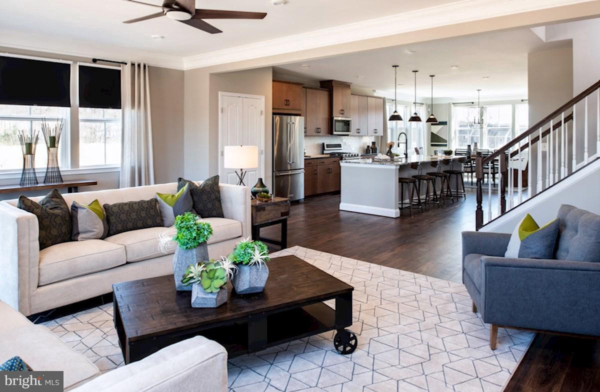 a living room with furniture and view of kitchen