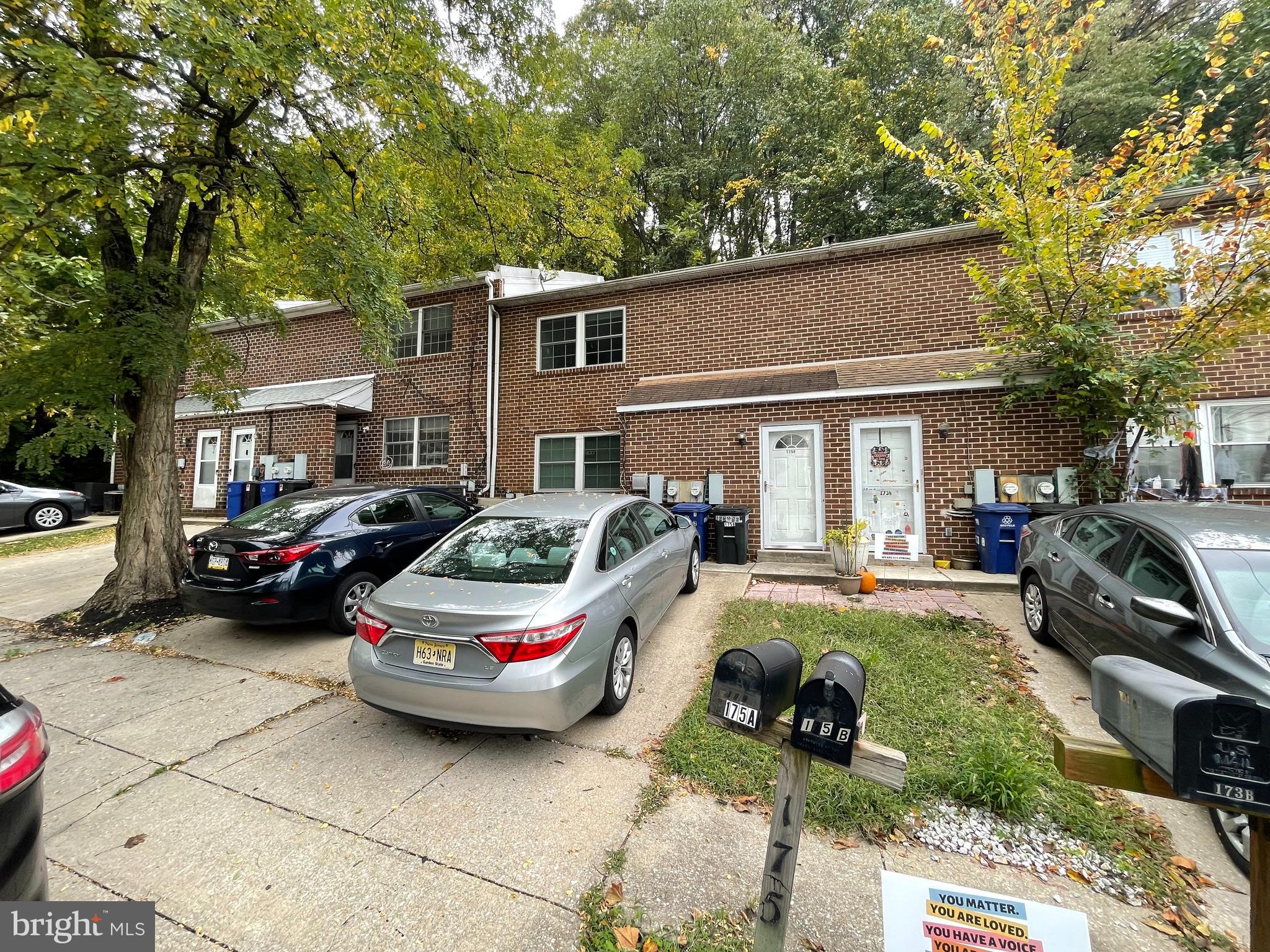 a front view of a house with cars parked