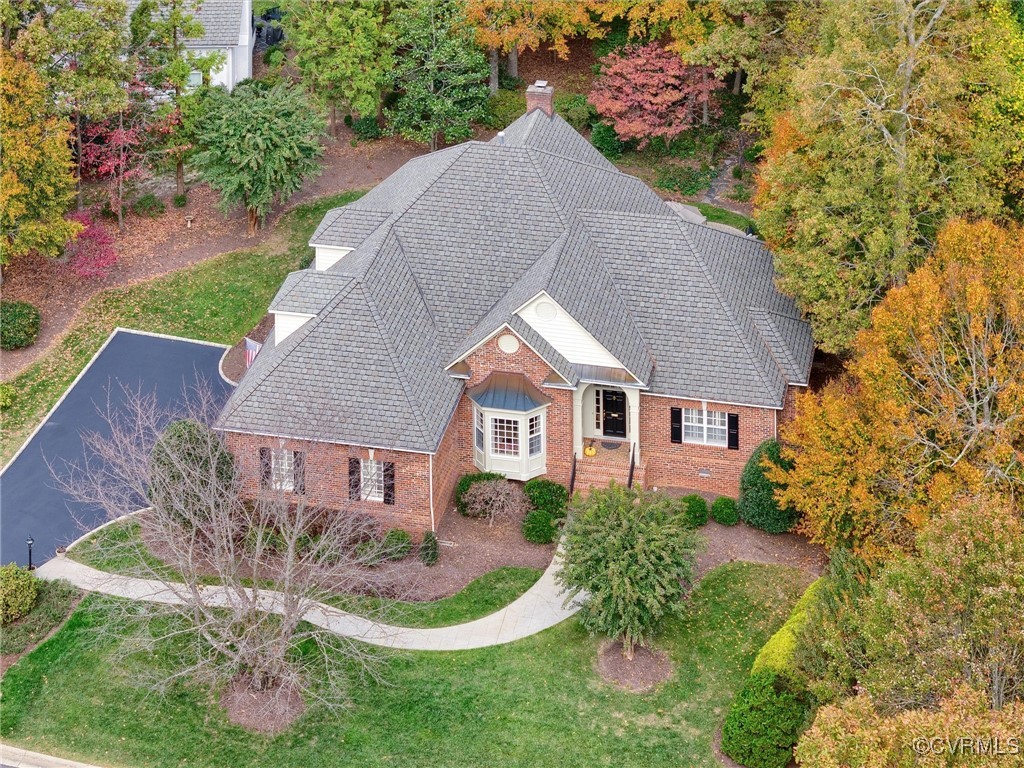 a aerial view of a house with yard and trees in the background