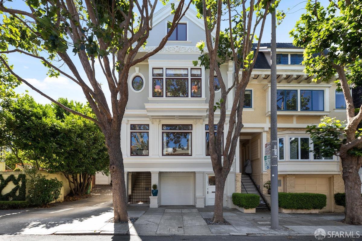 a front view of a house with a tree