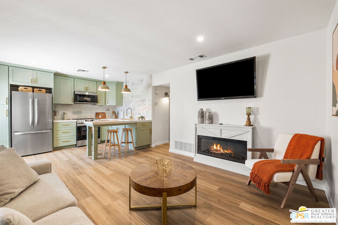 a living room with furniture a flat screen tv and a fireplace