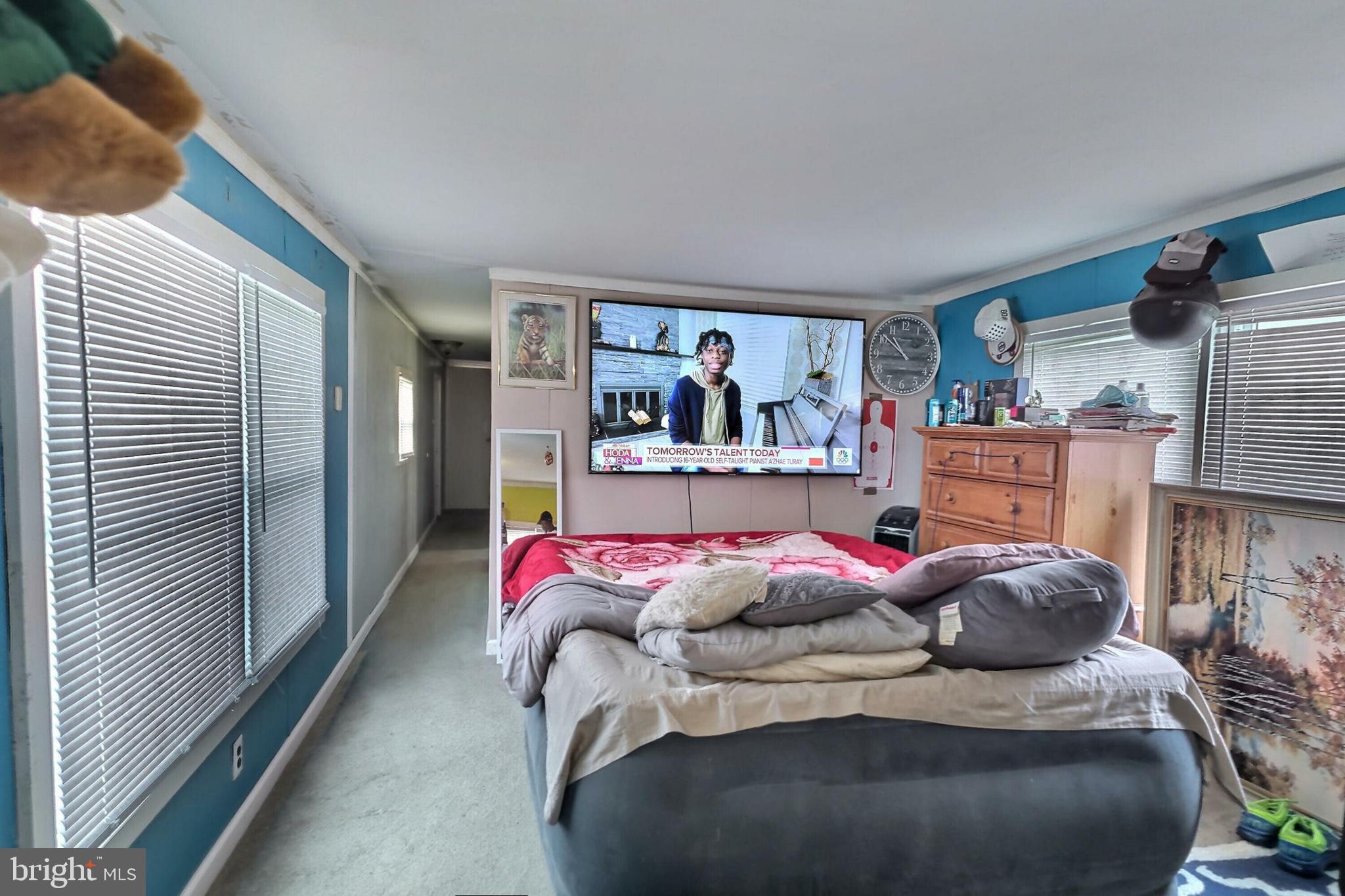 a bedroom with furniture and a painting on the wall