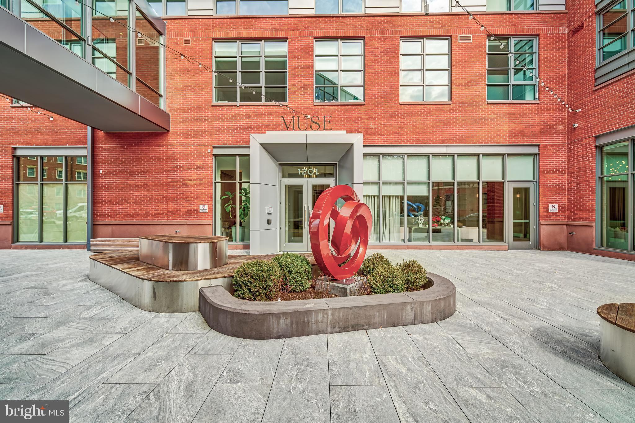 a front view of a brick building with a fountain