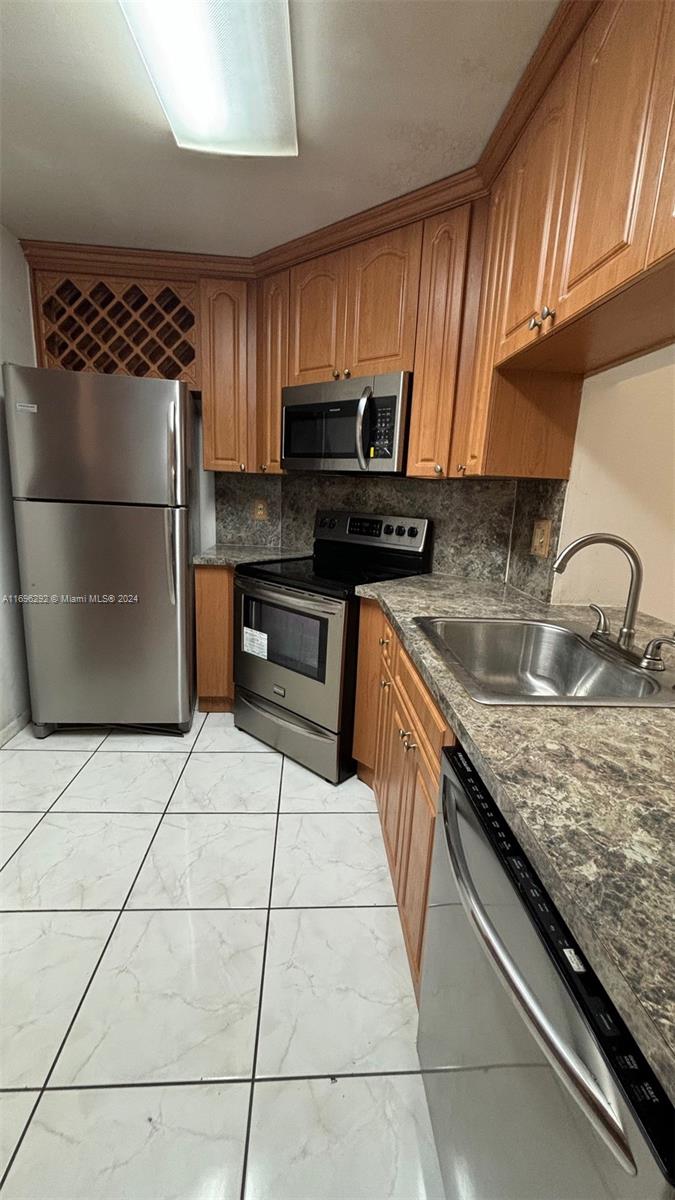 a kitchen with granite countertop a stove a sink and a microwave