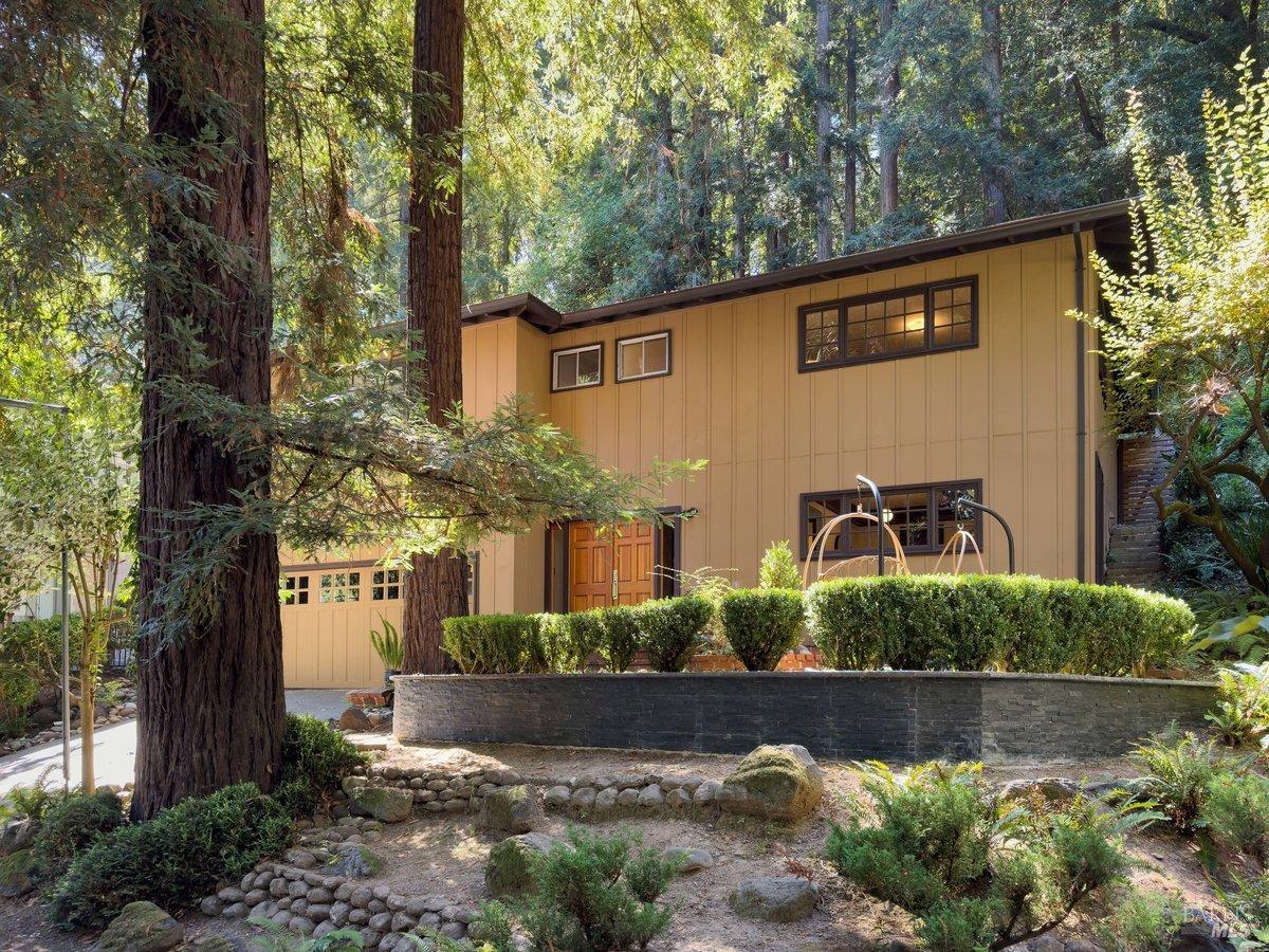 a front view of a house with a yard and potted plants