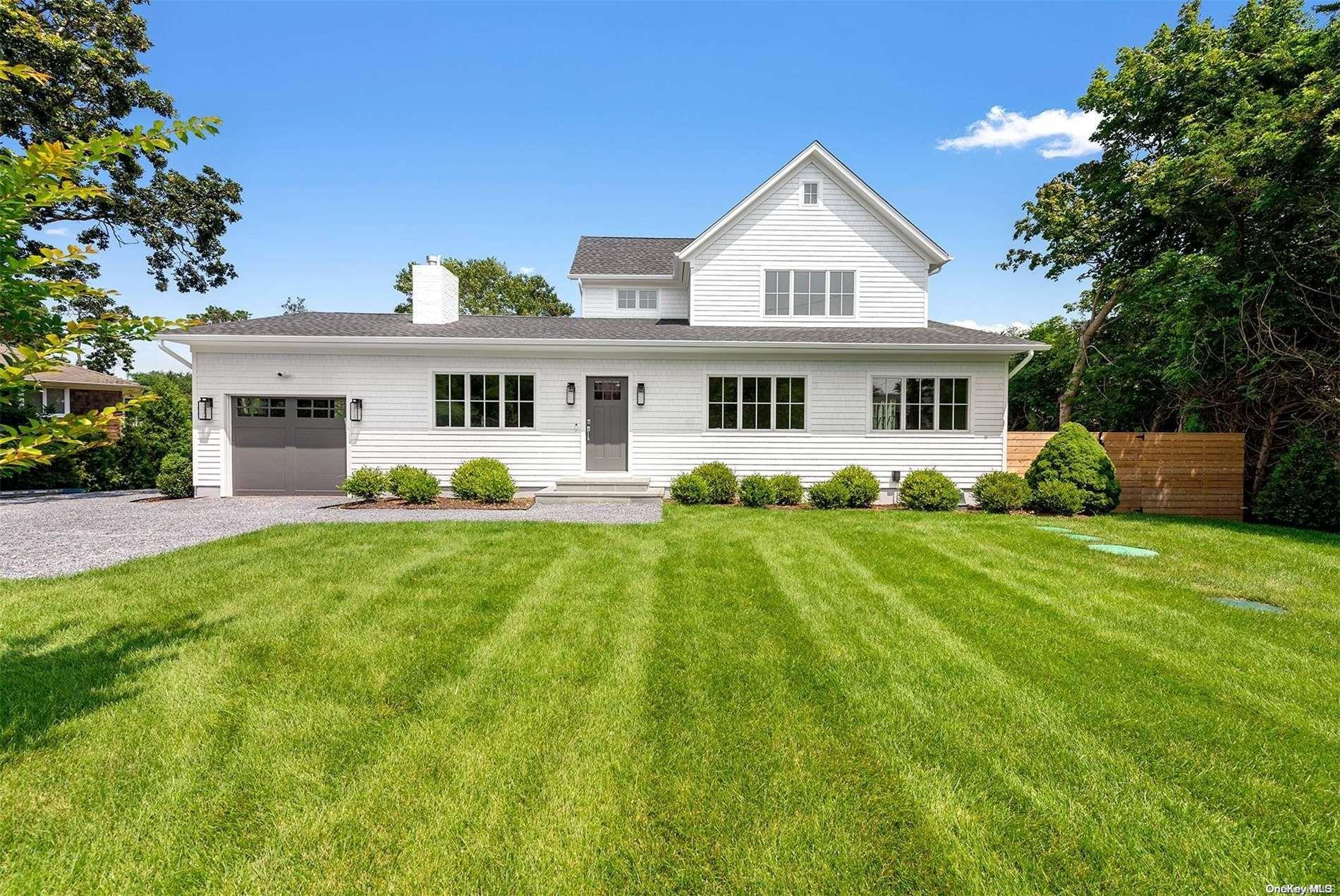 a front view of a house with a yard and trees