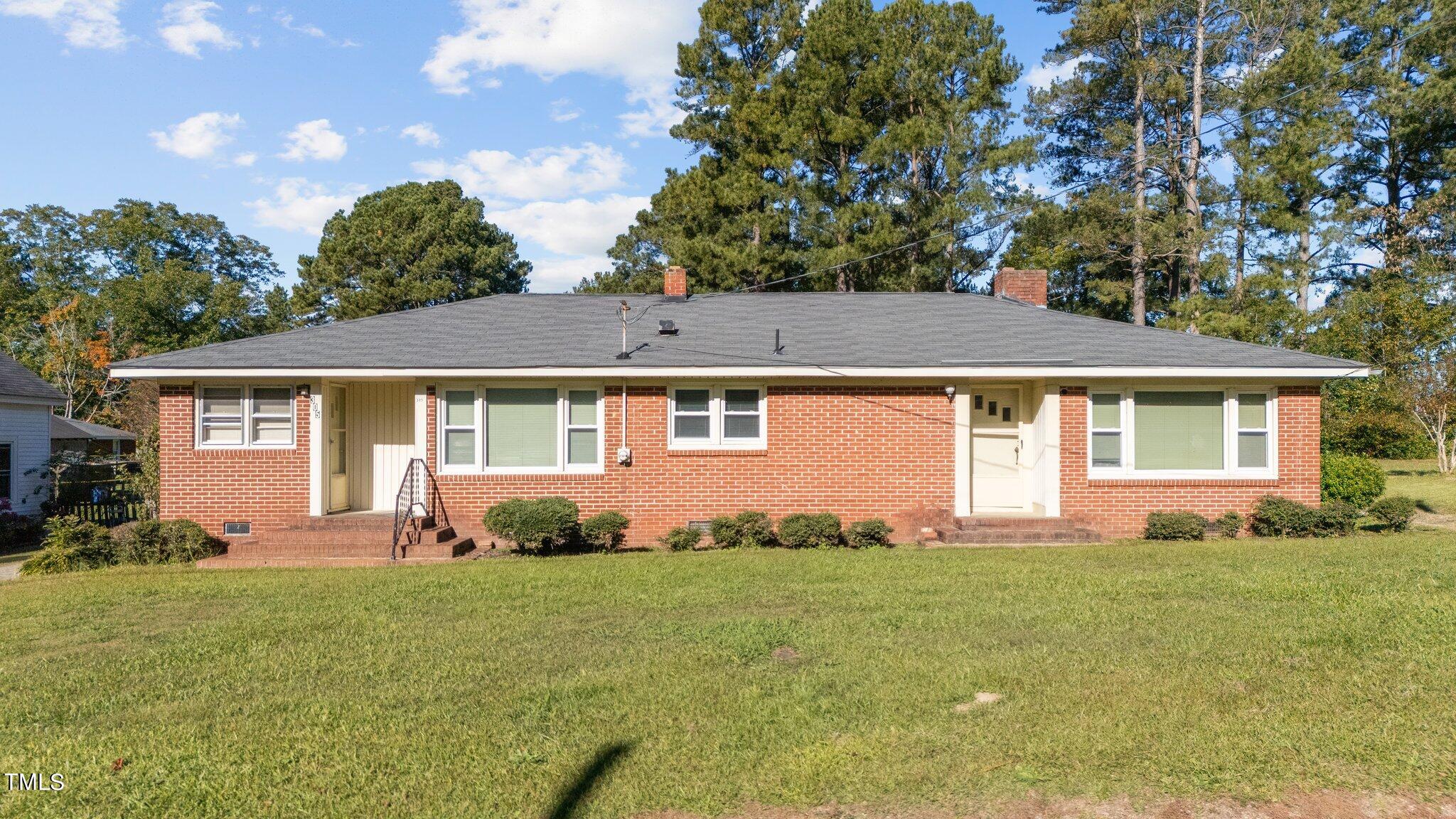 a front view of a house with a garden and yard