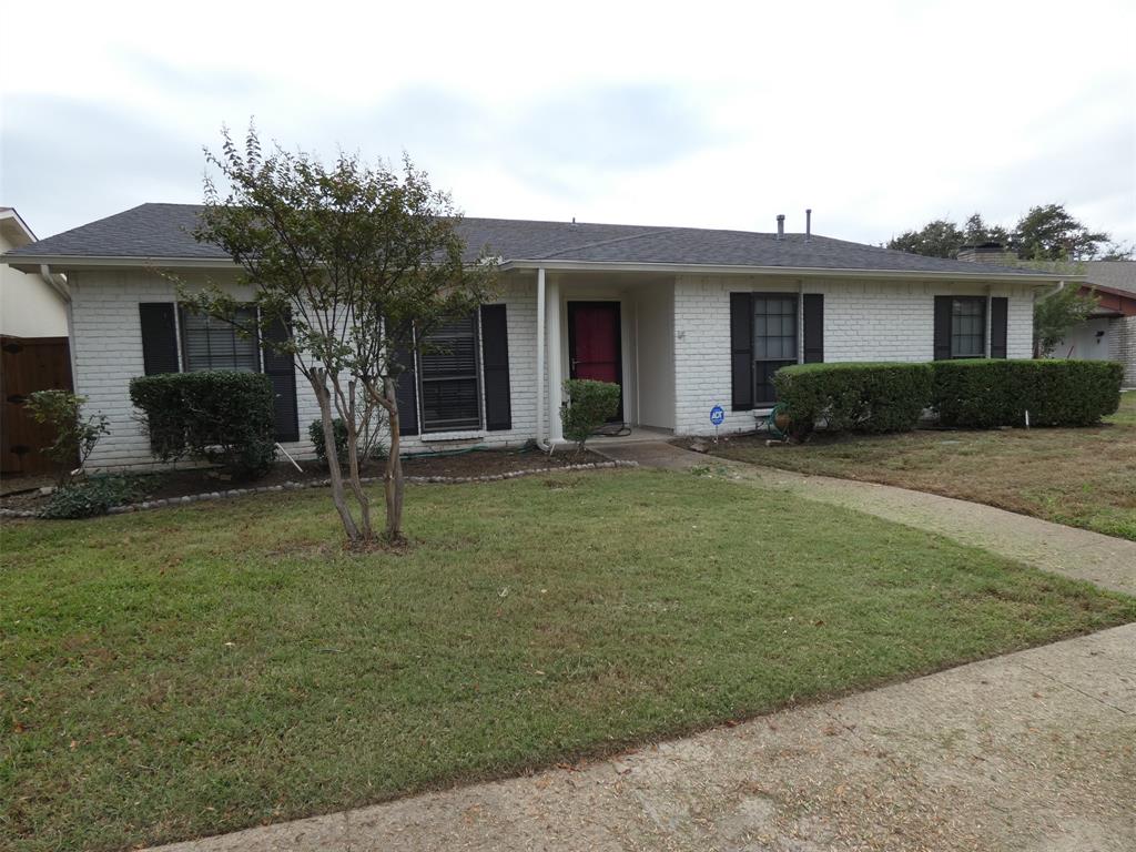 a front view of a house with a yard and potted plants