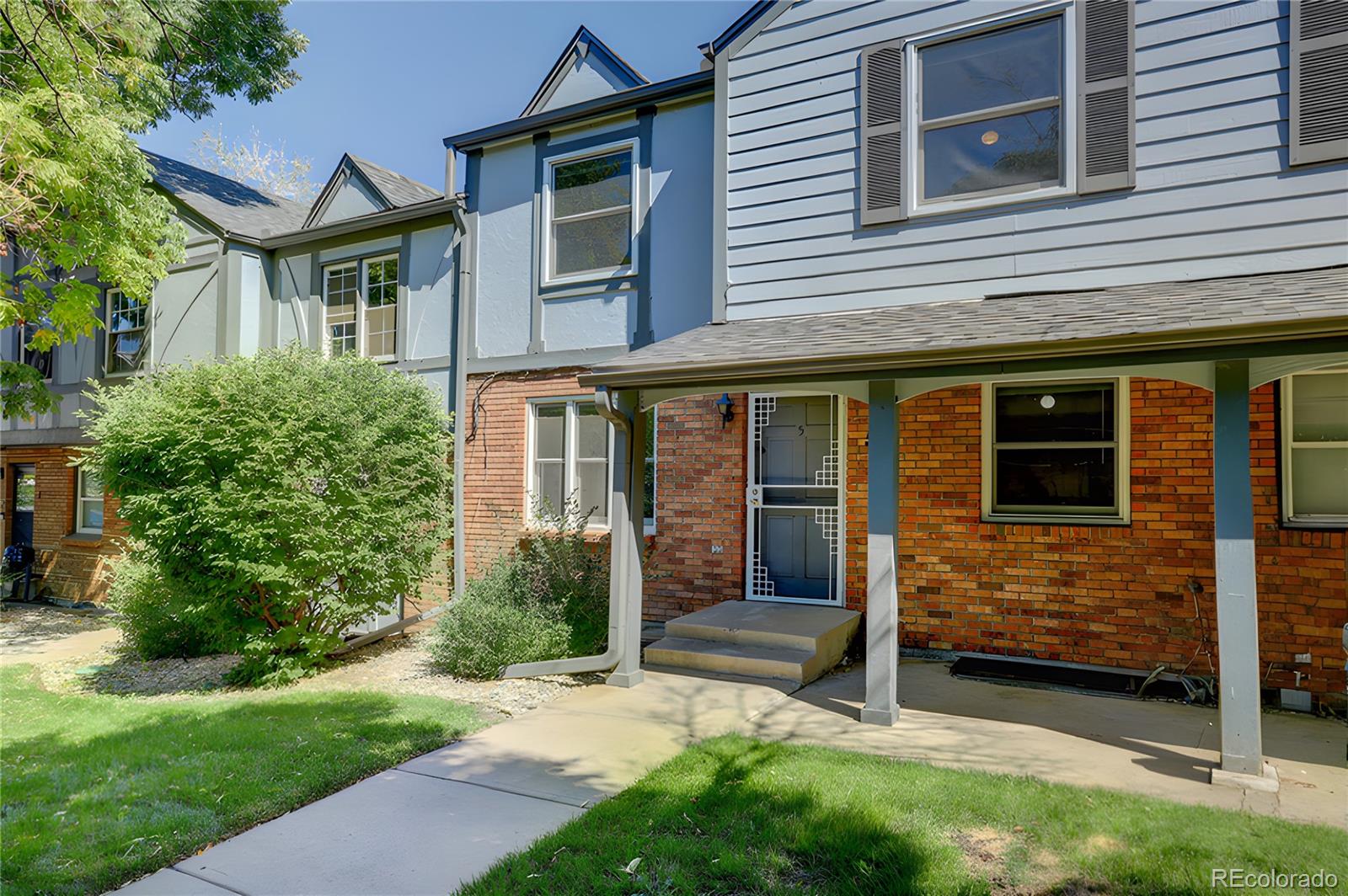 a view of a house with brick walls and a yard with plants