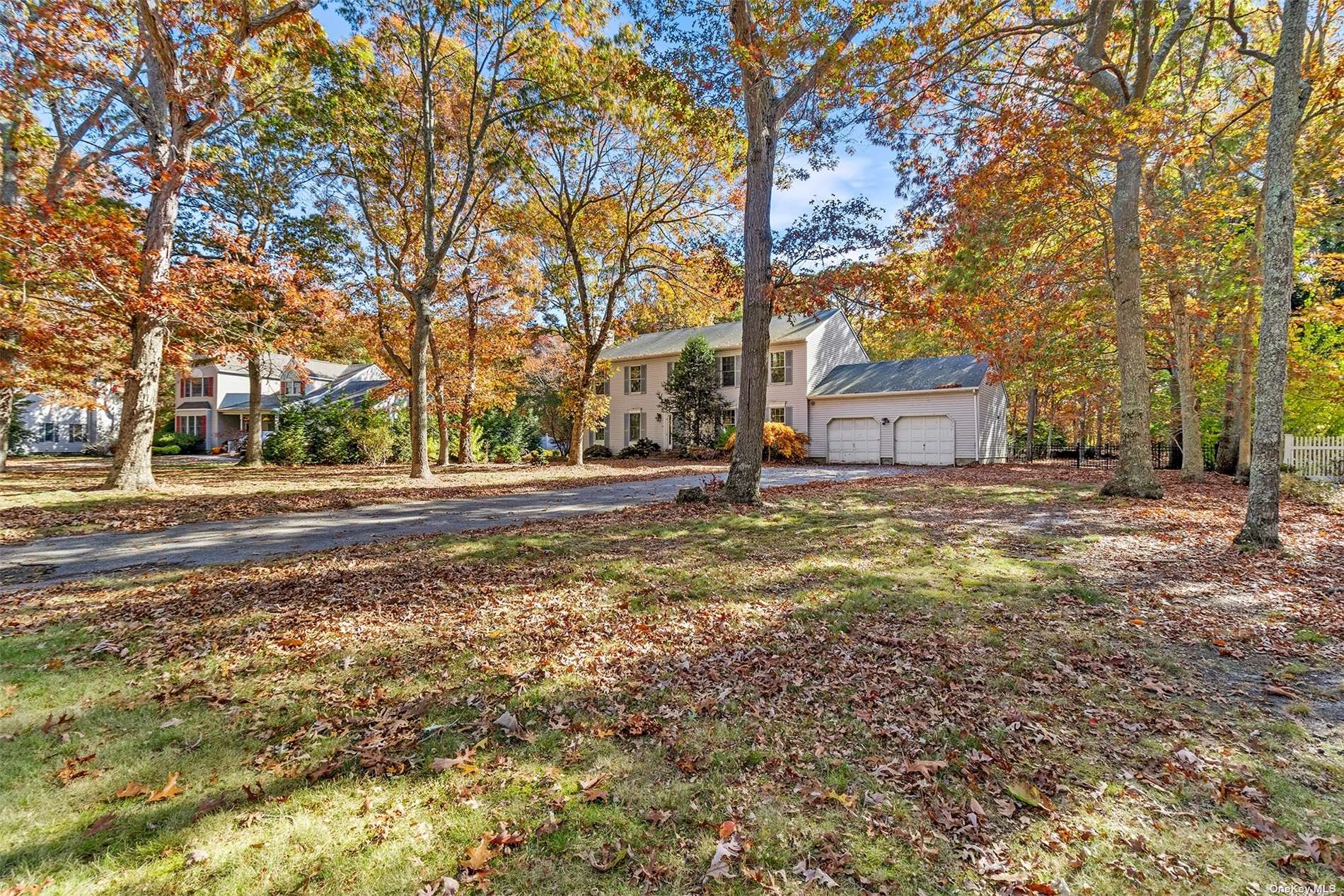 a front view of a house with a yard and trees