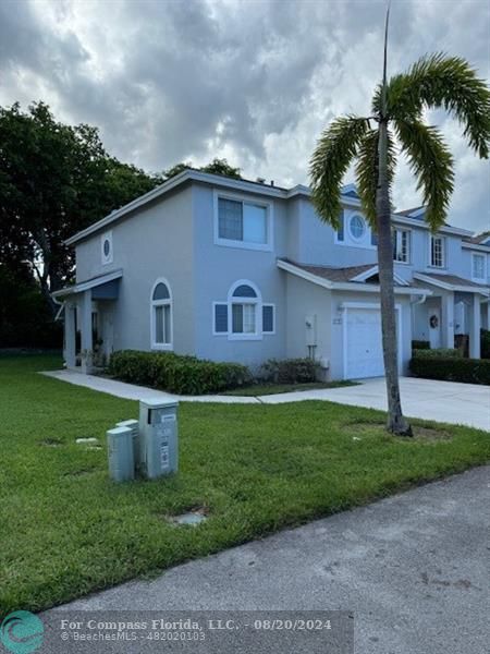 a front view of a house with a garden and yard