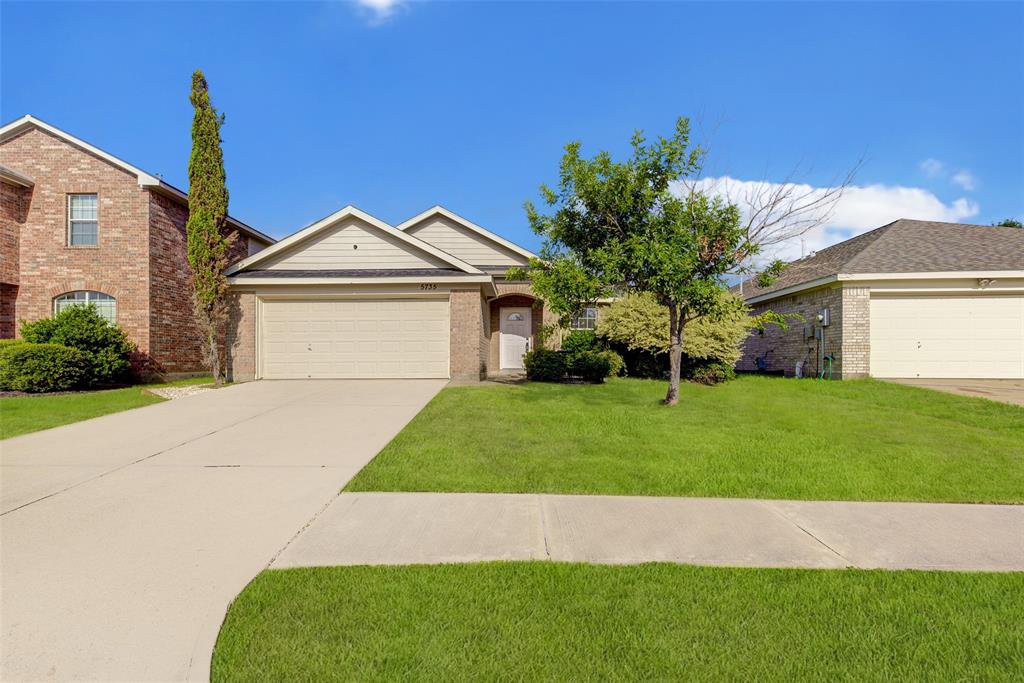 a front view of a house with a garden and yard