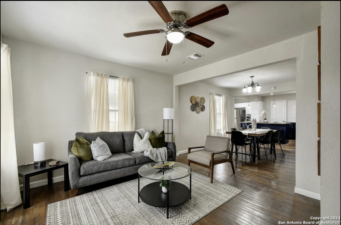 a living room with furniture and a wooden floor