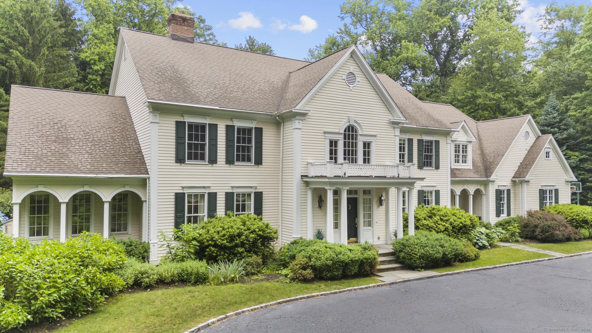 a front view of a house with a yard and trees