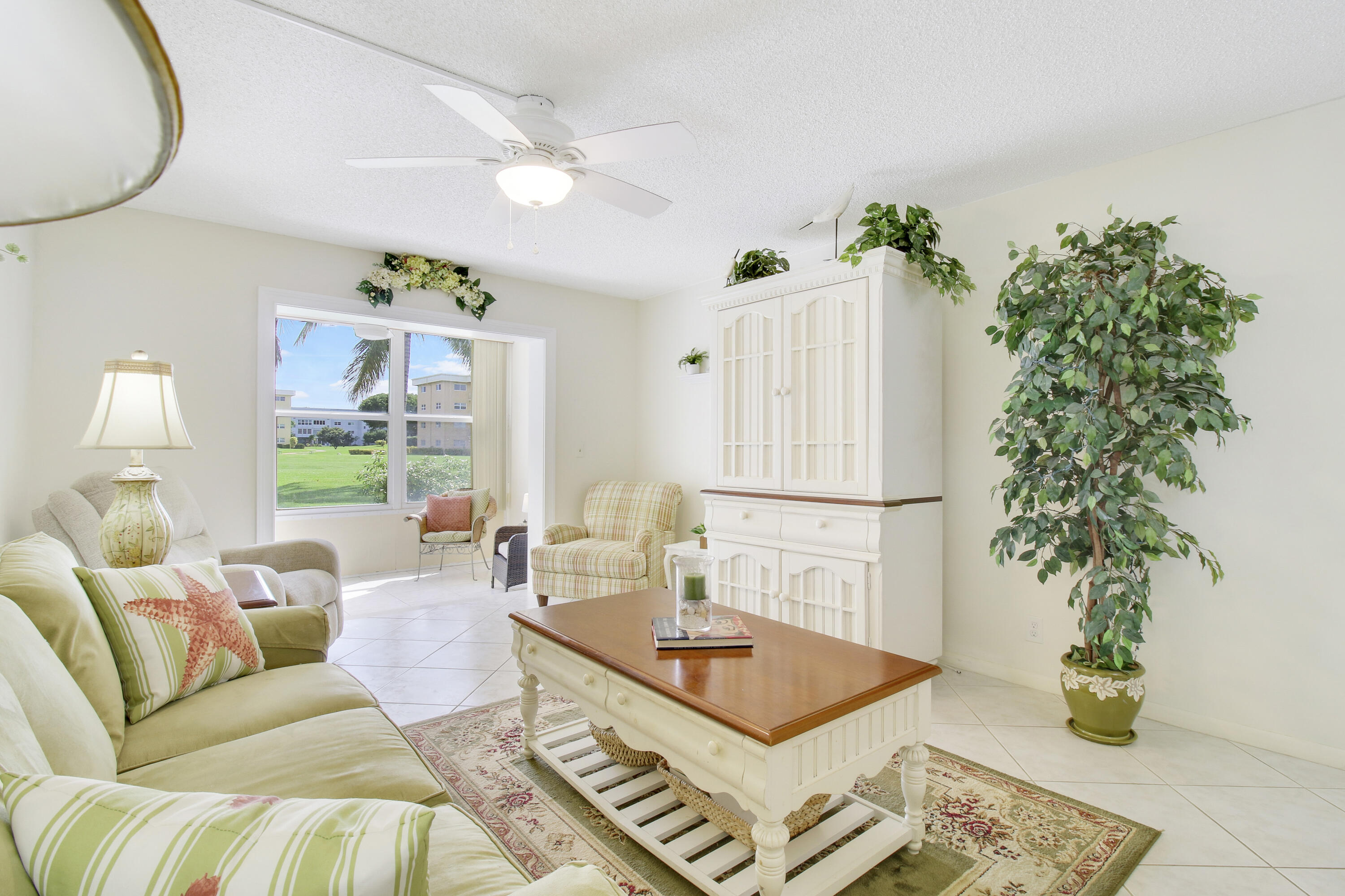 a living room with furniture and a potted plant