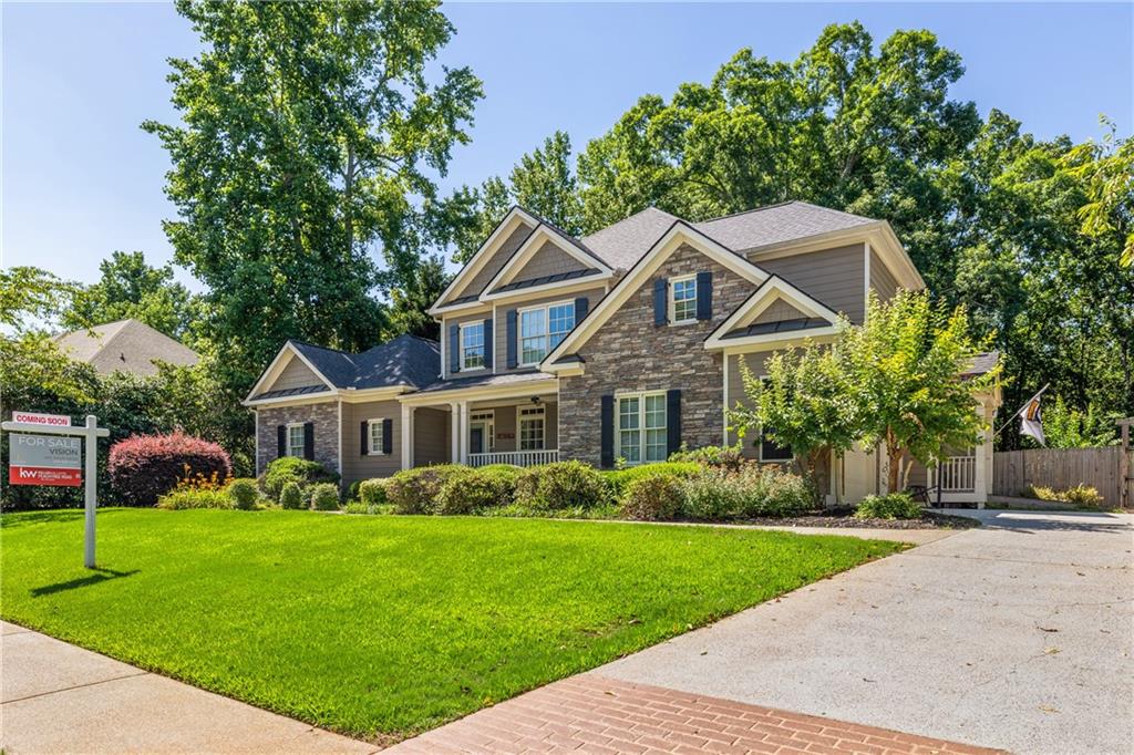 a front view of a house with a yard and trees