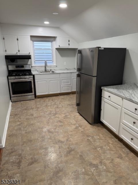 a kitchen with white cabinets and refrigerator