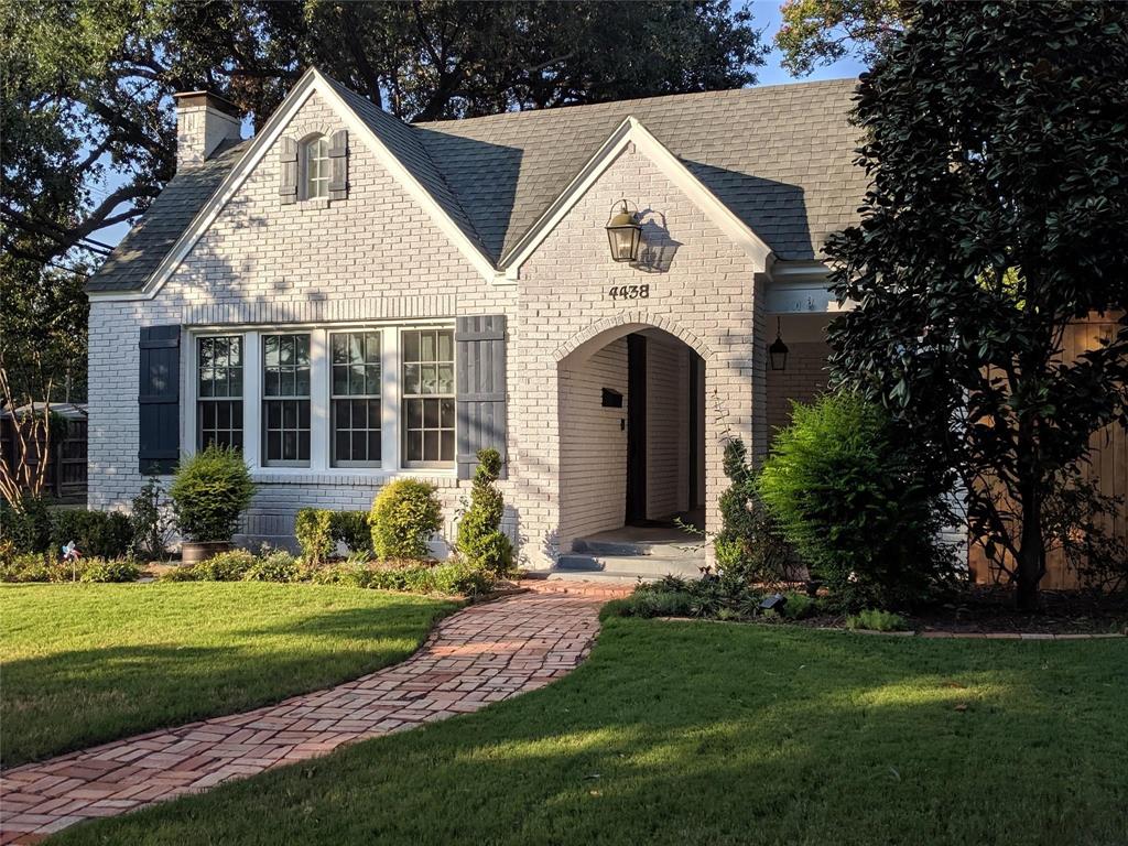 a front view of a house with a garden and plants