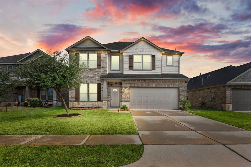 a front view of a house with a yard and garage