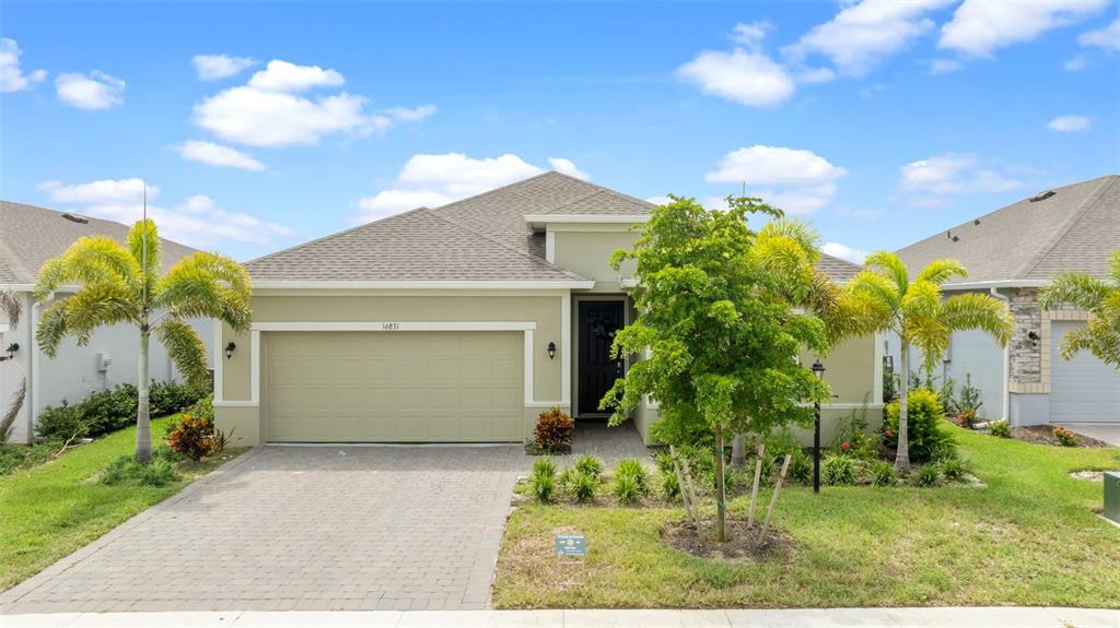 a front view of a house with a yard and potted plants