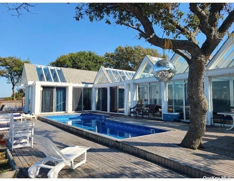 a front view of a house with swimming pool and dining table