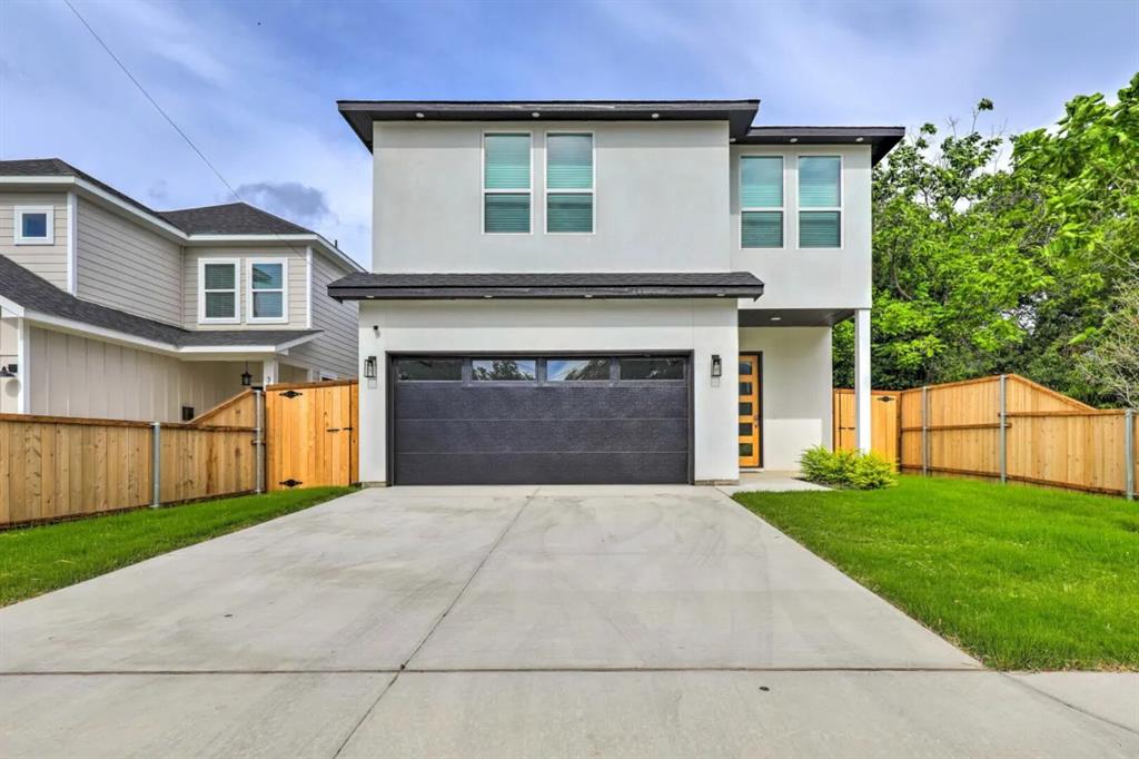 a front view of a house with yard and parking