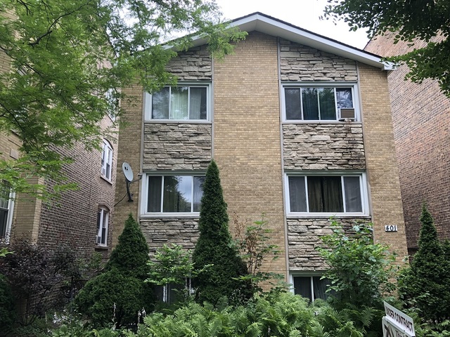 a front view of a house with plants