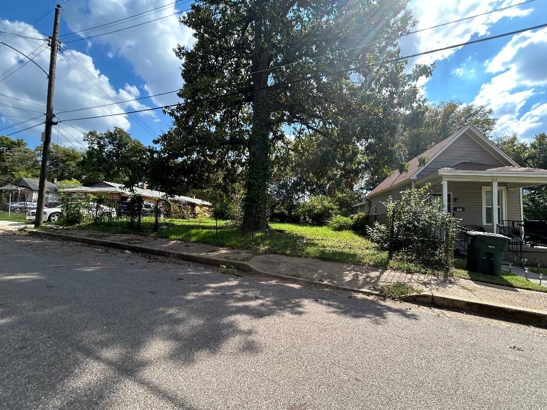 a view of a house with backyard and tree