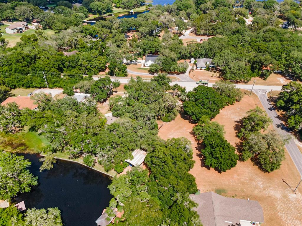 an aerial view of residential house with outdoor space and trees all around