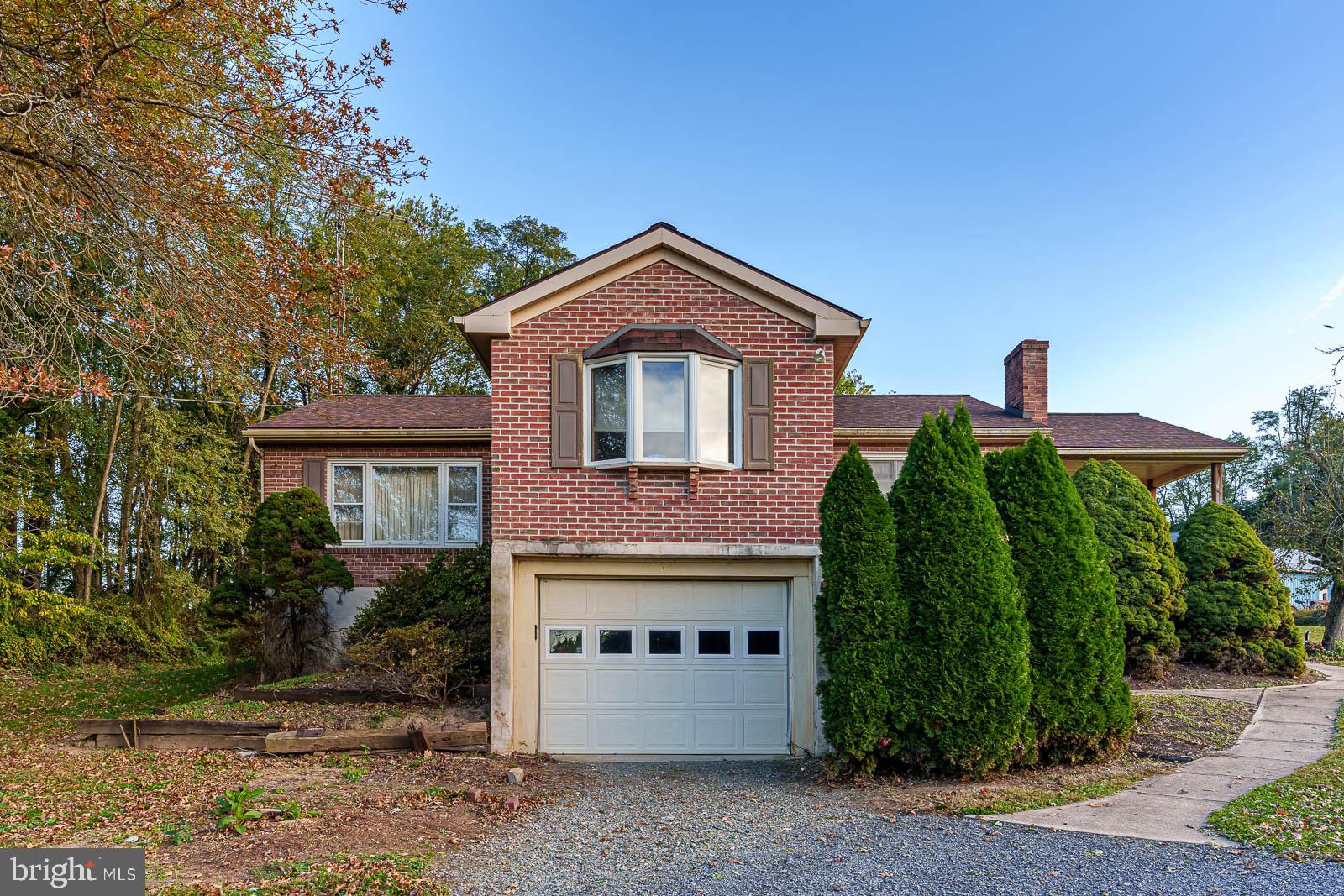 a front view of a house with a garden and plants