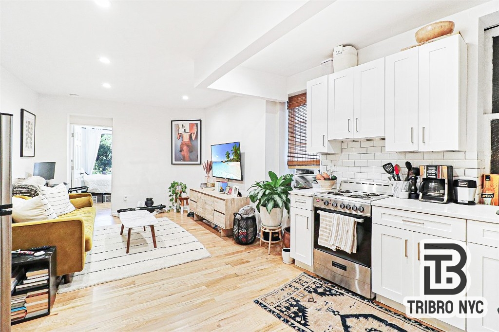 a living room with furniture a fireplace a flat screen tv and a window