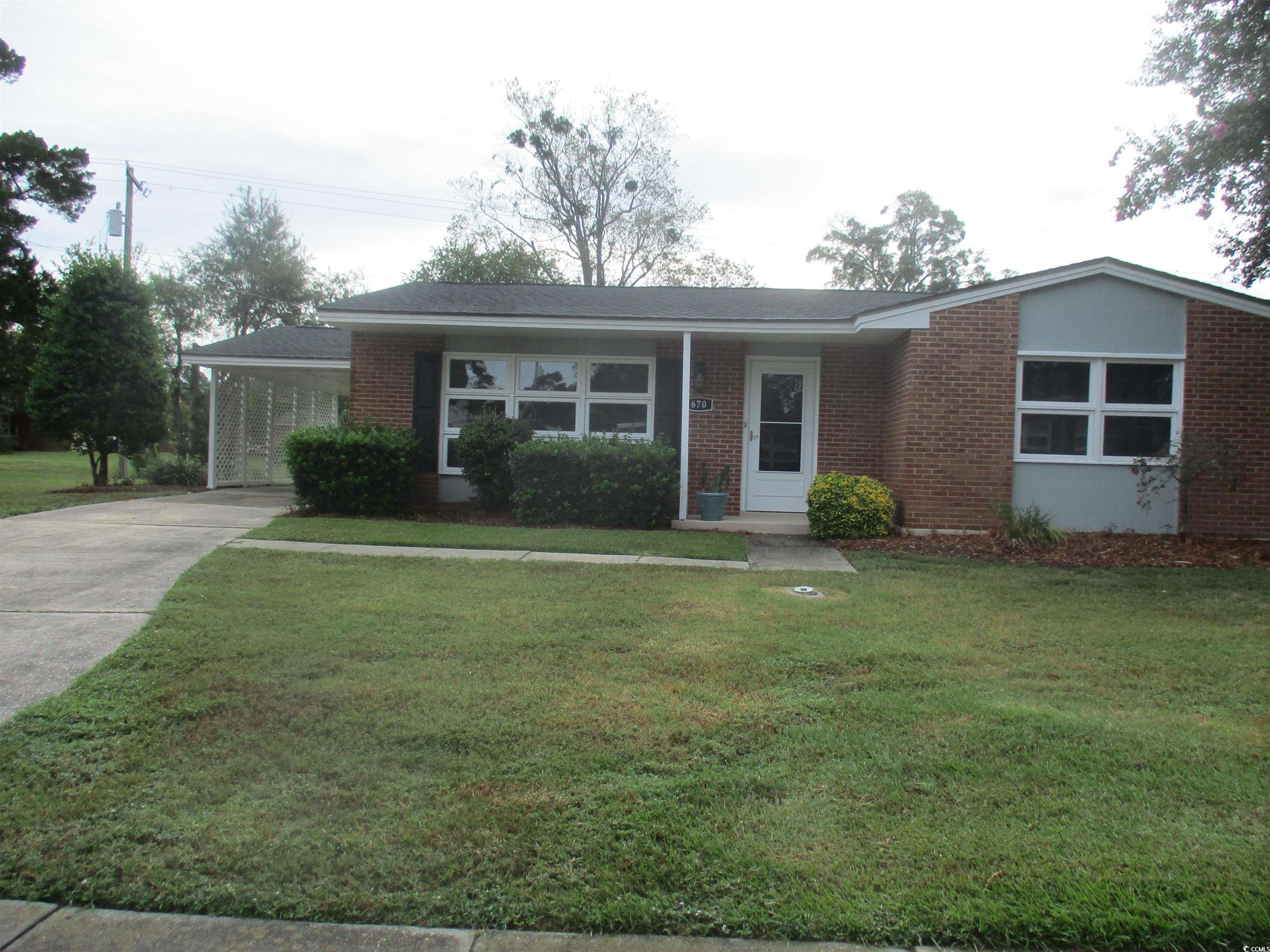 Single story home featuring a carport and a front