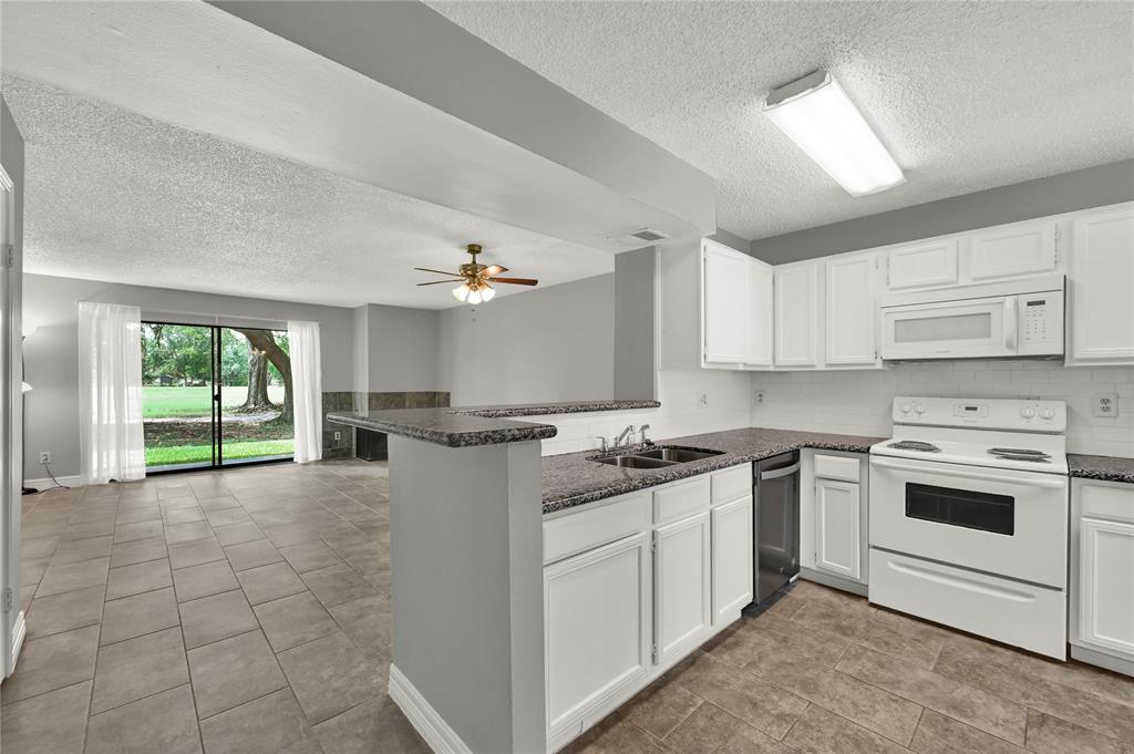 a kitchen with a stove a sink a microwave and cabinets