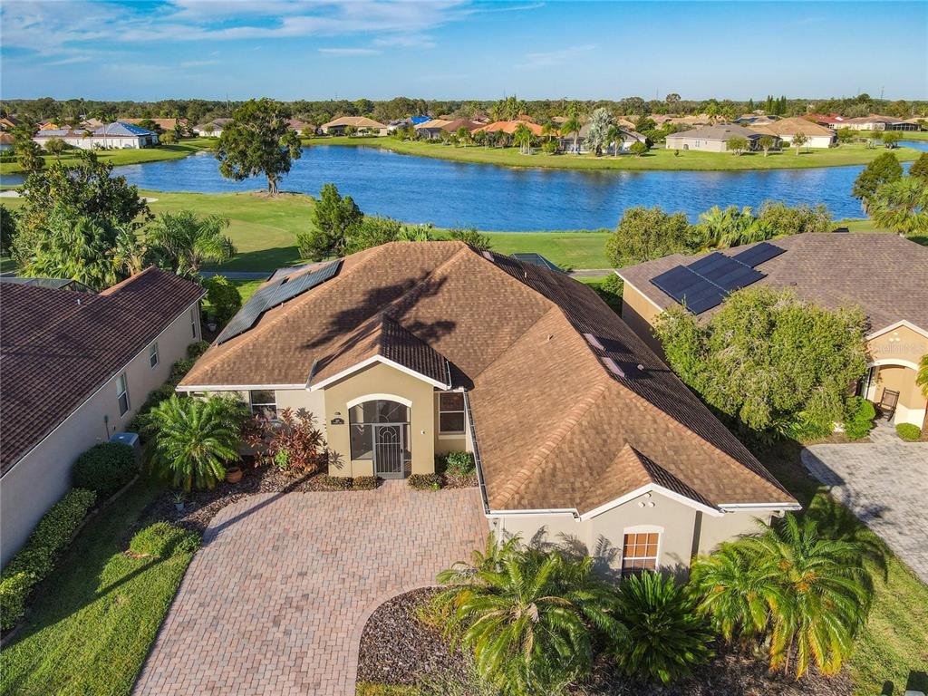 an aerial view of a house with a garden and lake view