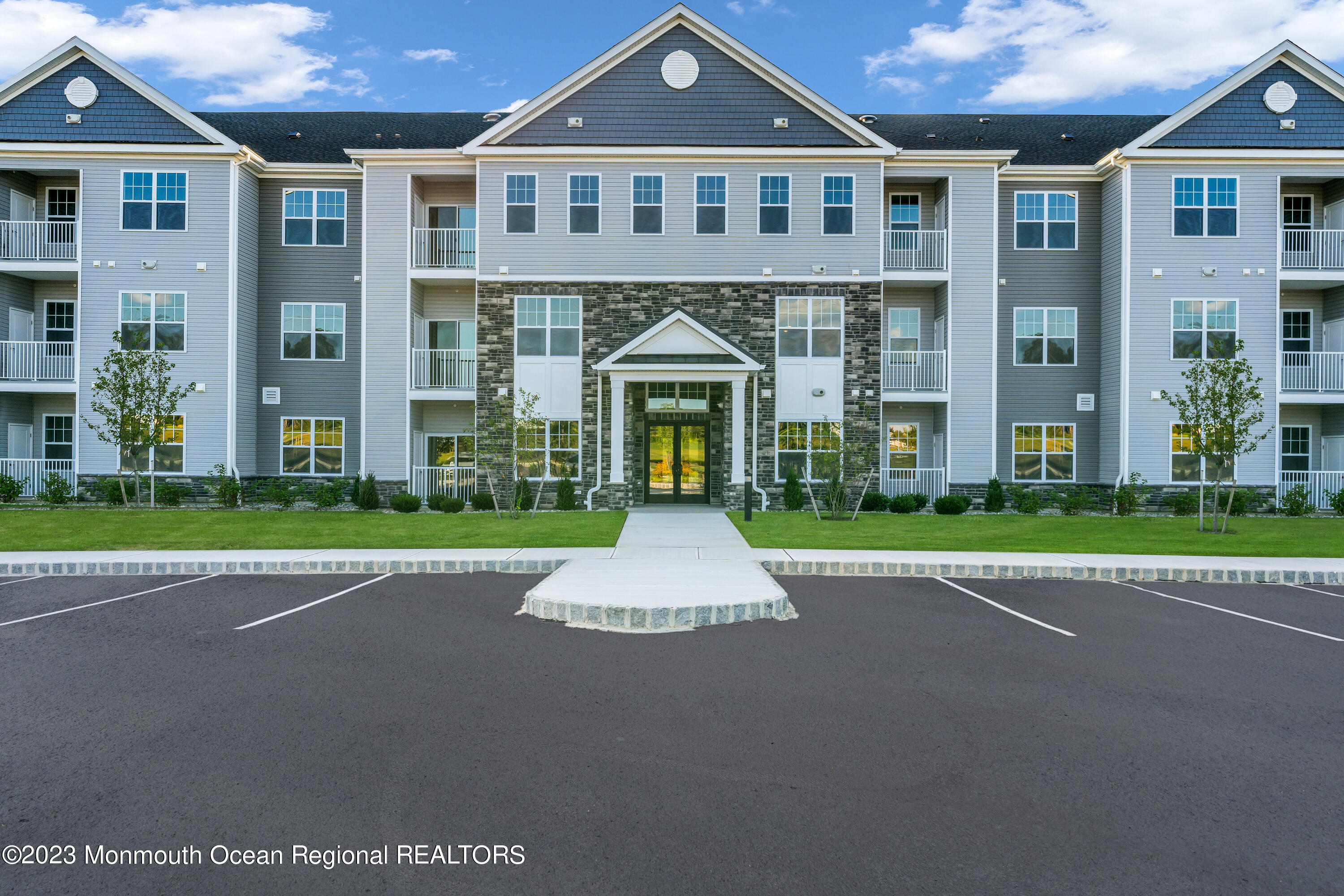 a front view of a residential apartment building with a yard