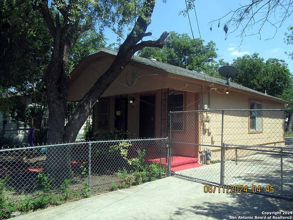 a side view of a house with a tree