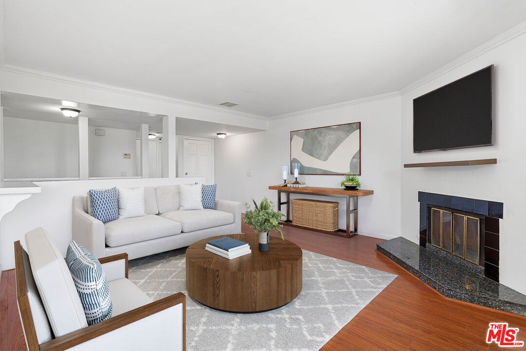 a living room with furniture a flat screen tv and a fireplace